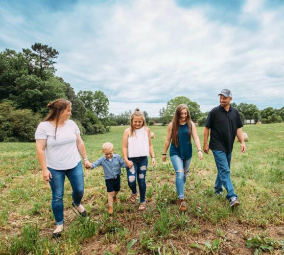 family of fve walking in field