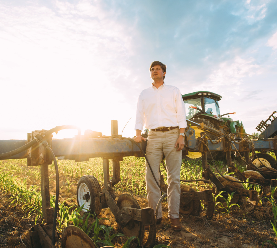 man leaning on farming equipment