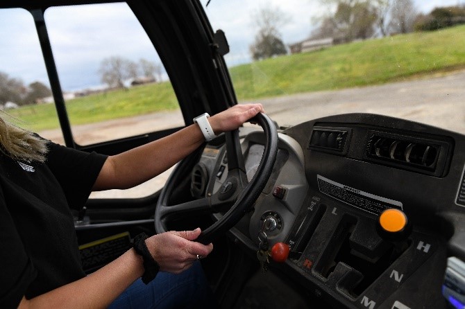 A female driving a piece of equipment