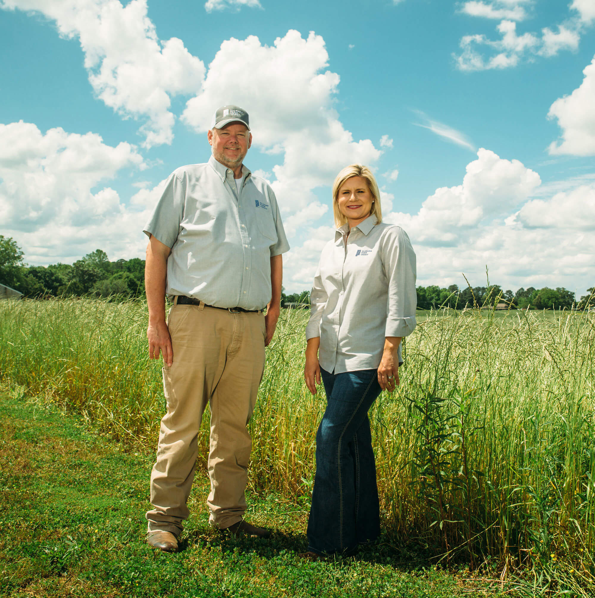 2 alabama farm credit employees standing in field
