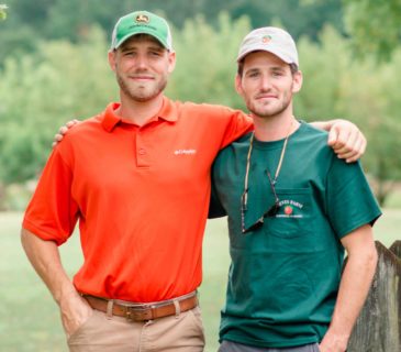 2 men with arms around each others shoulders